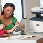 Deux femmes utilisant une tablette devant une imprimante multifonction Xerox® VersaLink® B415
