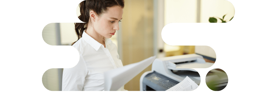 Une employée examine des documents imprimés avec une imprimante multifonction professionnelle 2026 dans un bureau.