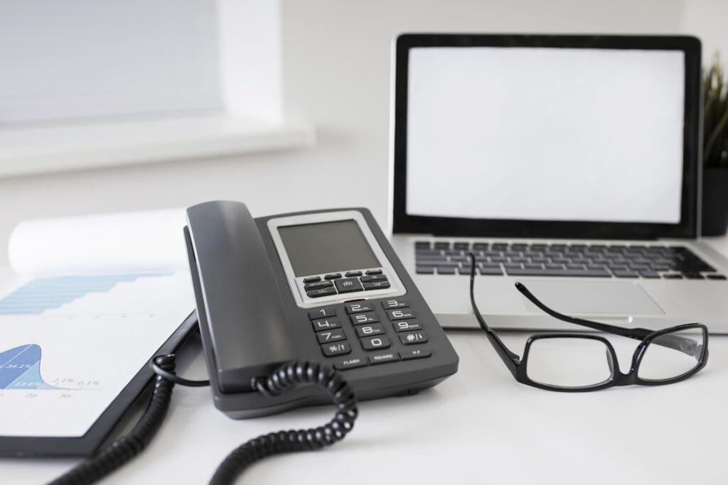 Rapport d'audit de la sauvegarde informatique sur un bureau de direction, avec ordinateur portable et t&eacute;l&eacute;phone